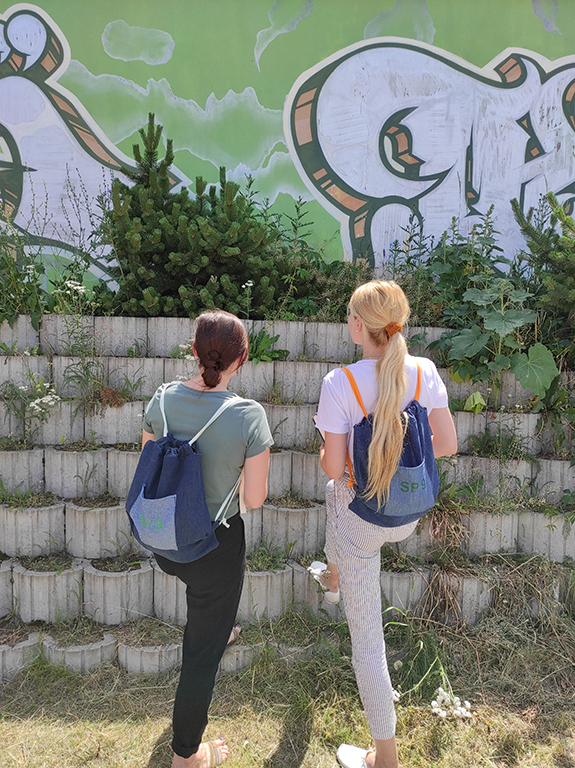 Dziewczęta przy muralu z plecakami z dżinsu