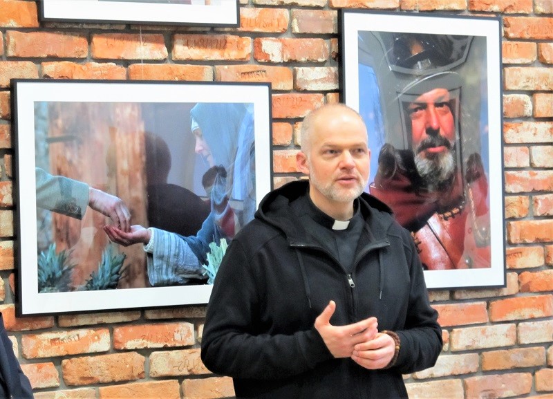  Ksiądz Dariusz Kowalewski na tle swoich zdjęć