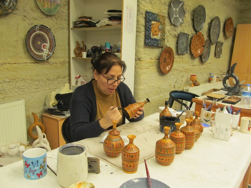 Kobieta ozdabiająca ceramikę w Muzeum Ceramiki.