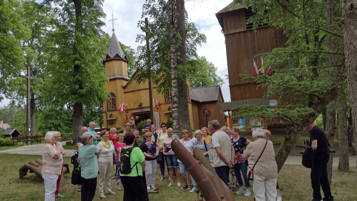 Grupa ludzi  przy kościele w Mikaszówce